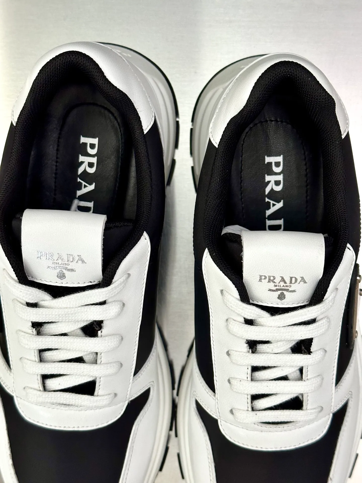 💰740 Prada/Prada men's new mesh stitching sneakers. This sneaker presents a modern version, reinterpreting the brand's archive style with clean lines and smooth details. The shoes are made of calf leather and technical fabric, with a triangular metal logo on the outside, bright TPU decoration on the heel, and a longer and padded inner heel design for a more comfortable fit. The tongue is decorated with a silk-screen logo, and is paired with a hollow rubber sole on the heel. The full cowhide lining comes standard with logo cowhide foot pads, making the upper foot taller, more comfortable, and versatile! Comes with full original packaging! Size: 39-40-41-42-43-44 standard leather shoe size (45 can be customized and does not support returns)